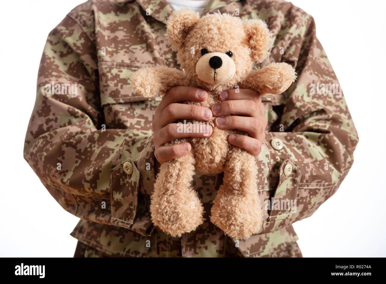 Father in the Army. Young soldier holding a teddy bear standing on white background Stock Photo