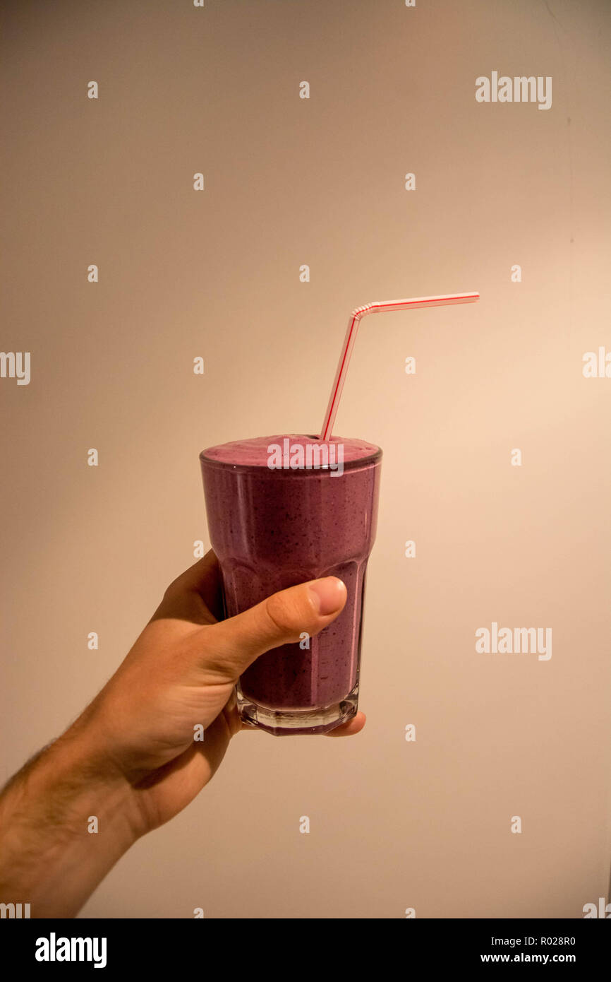 https://c8.alamy.com/comp/R028R0/human-hand-holding-a-pink-berry-smoothie-in-front-of-plain-white-background-R028R0.jpg