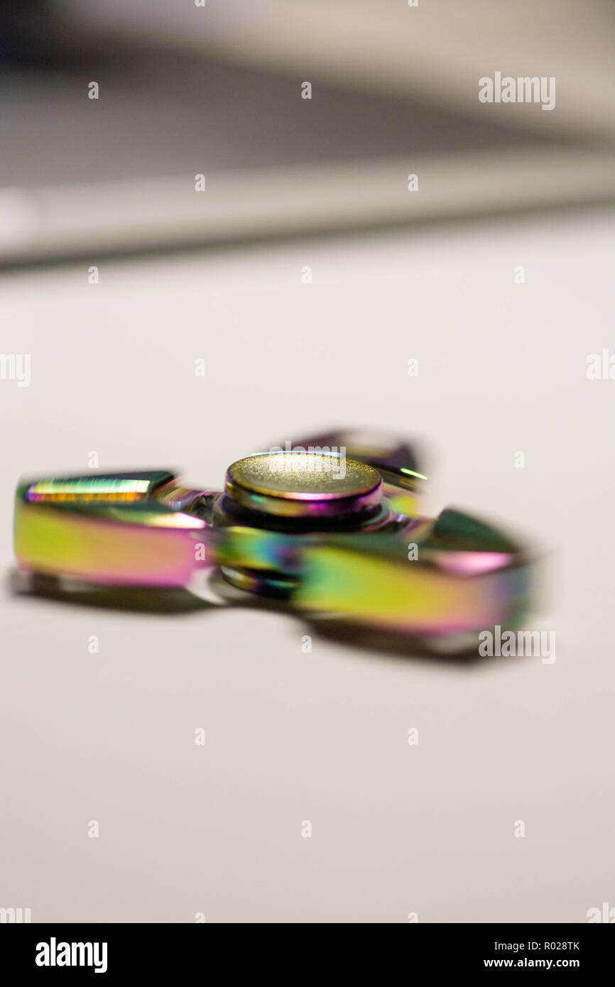 turning fidget spinner in motion lieing on table Stock Photo