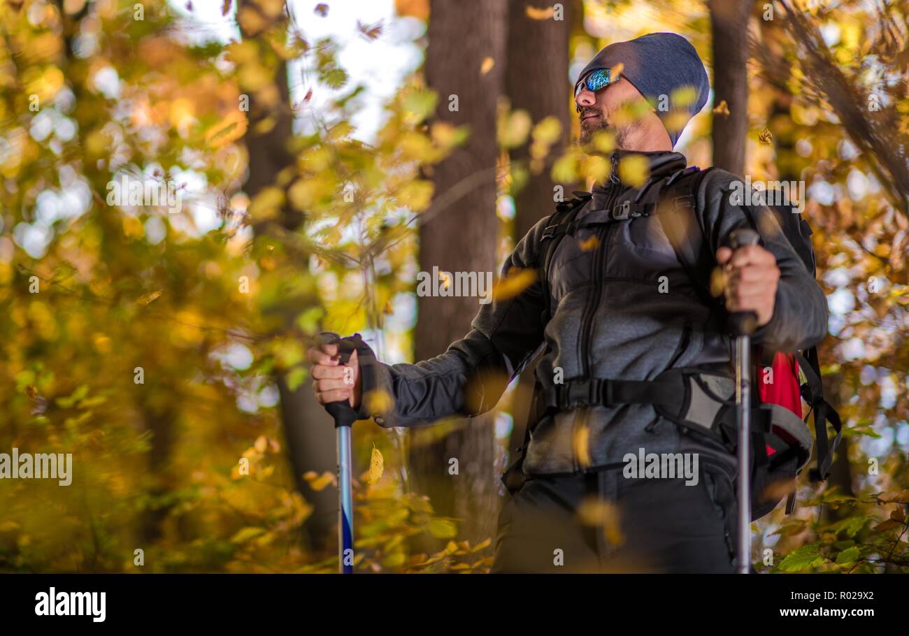 Caucasian Backpacking Trekker on Scenic Forest Trail. Fall Foliage