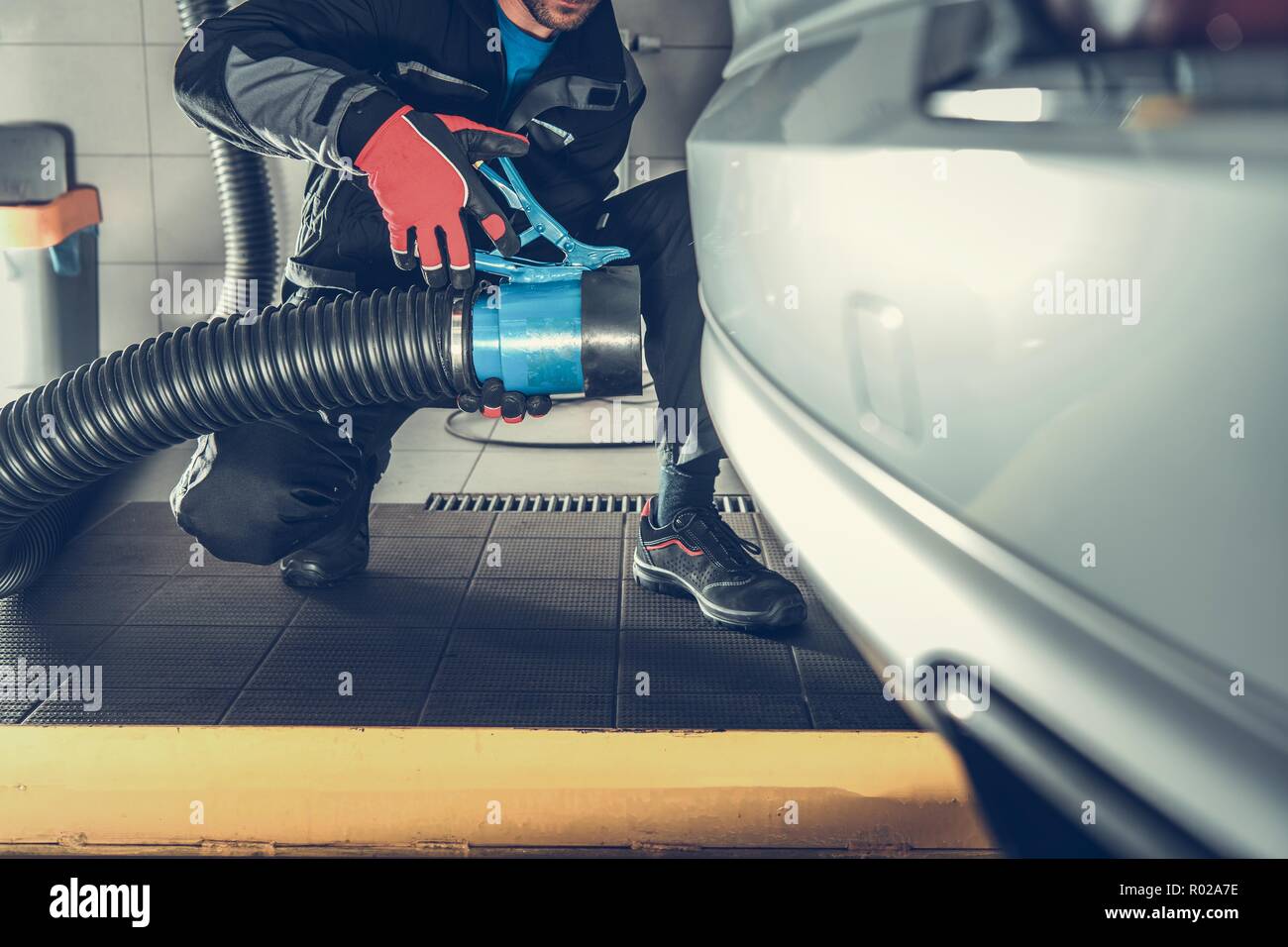Removing Car Pollution While Maintenance Inside the Auto Service Building. Automotive Equipment. Stock Photo