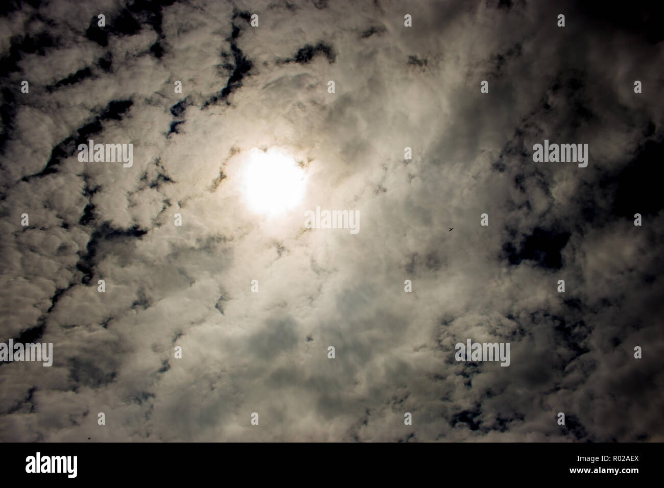 Dark black sky with scattered fluffy clouds Stock Photo