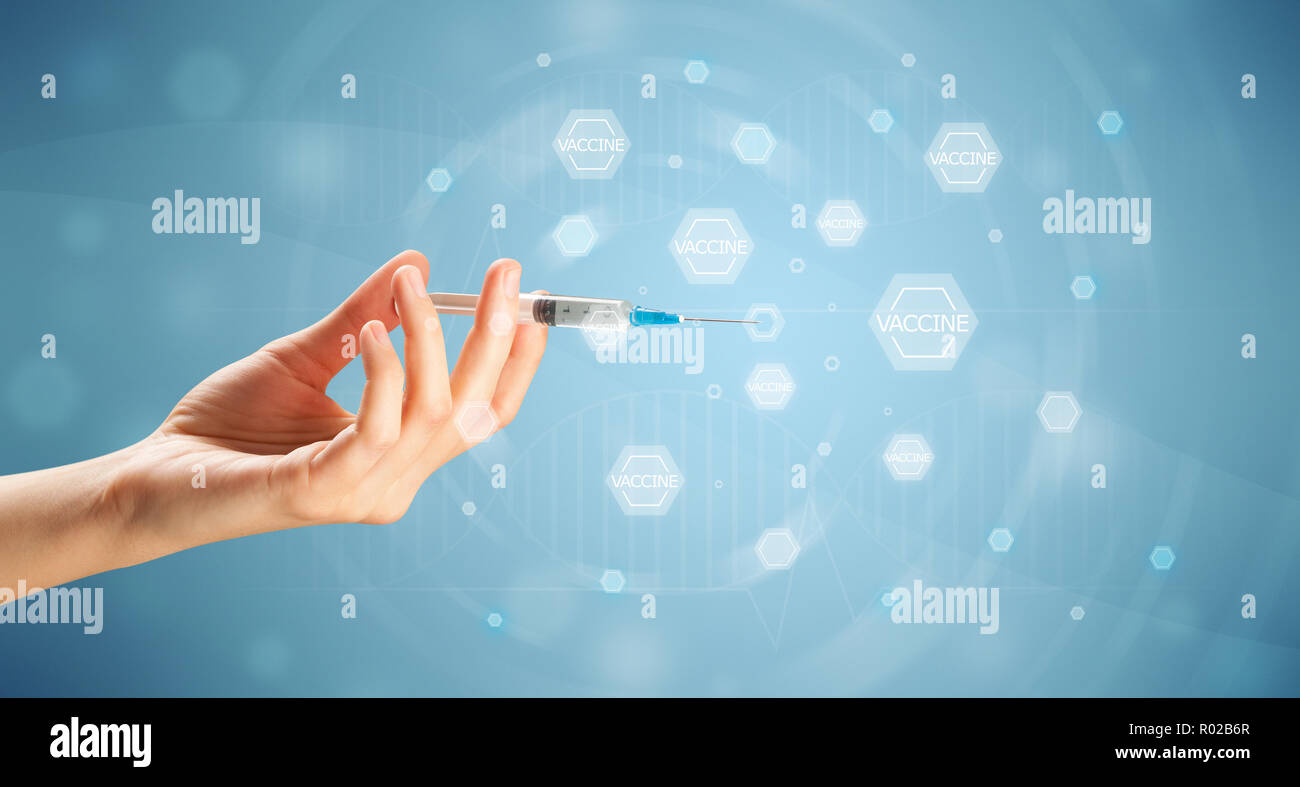 Female doctor hand holding syringe with blue background Stock Photo - Alamy