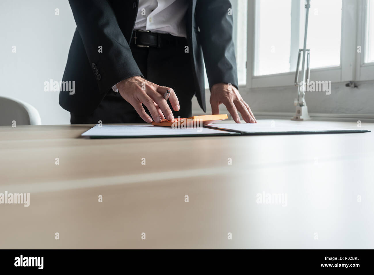 Financial Advisor Standing At His Desk Making Quick Calculations
