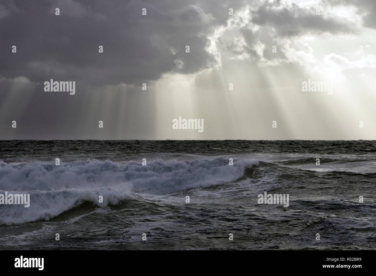 Stormy sea sky with sunbeam between clouds Stock Photo