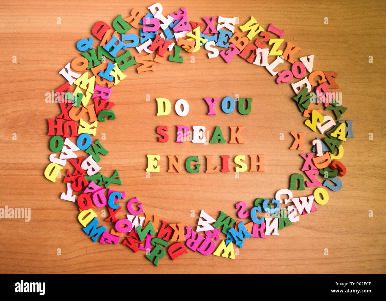 Do you speak english wooden letters around a pile of other over office table board surface Stock Photo