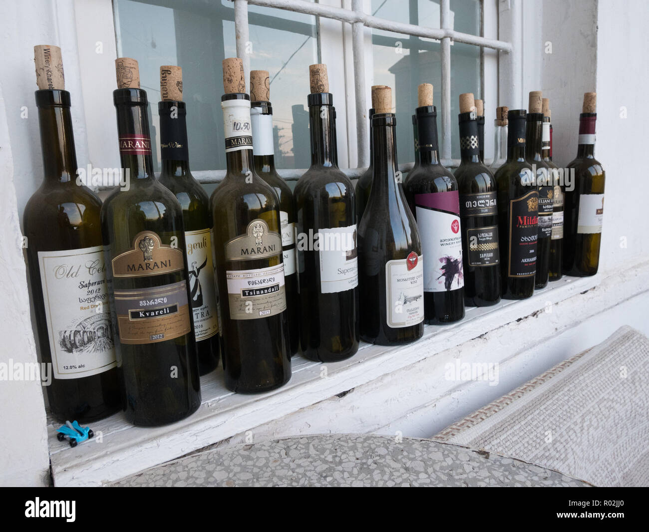 Empty Georgian Wine bottles lined up on a window sill in Tbilisi, Georgia. Stock Photo
