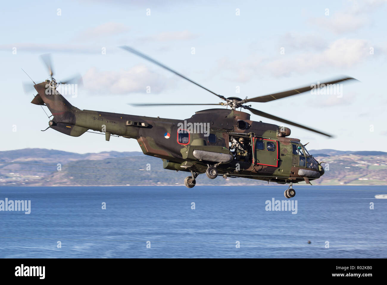 A Dutch AS532 Super Puma helicopter securities the landing of infantrymen  on the beach of Trondheim Fjord, in Norway, during exercise Trident  Juncture 18. With around 50,000 personnel participating in Trident Juncture