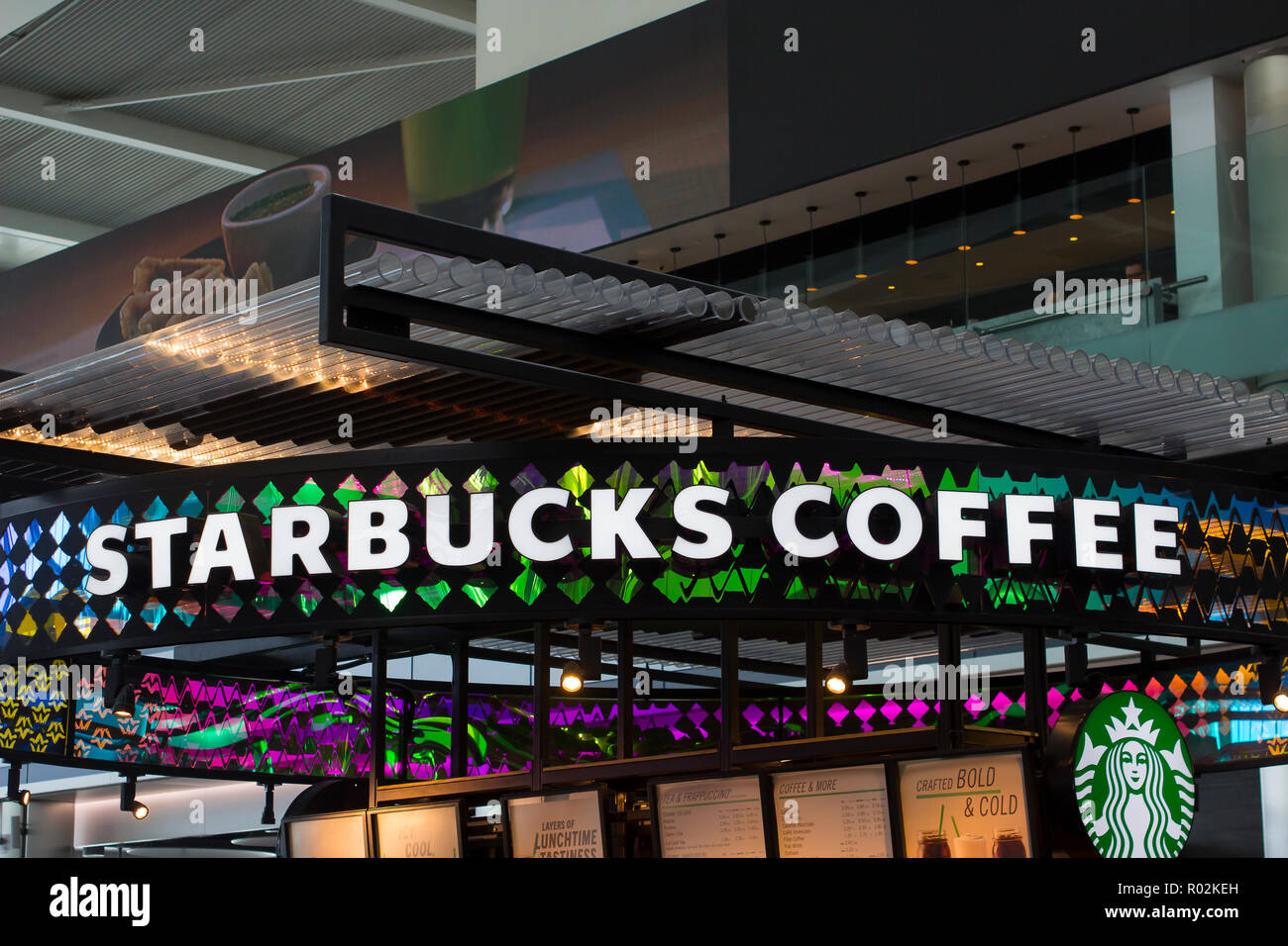 2 May 2018 A Starbucks coffee outlet with colorful overhead sign in Heathrow Airport in the modernTerminal 5 at Heathrow International Airport in Lond Stock Photo