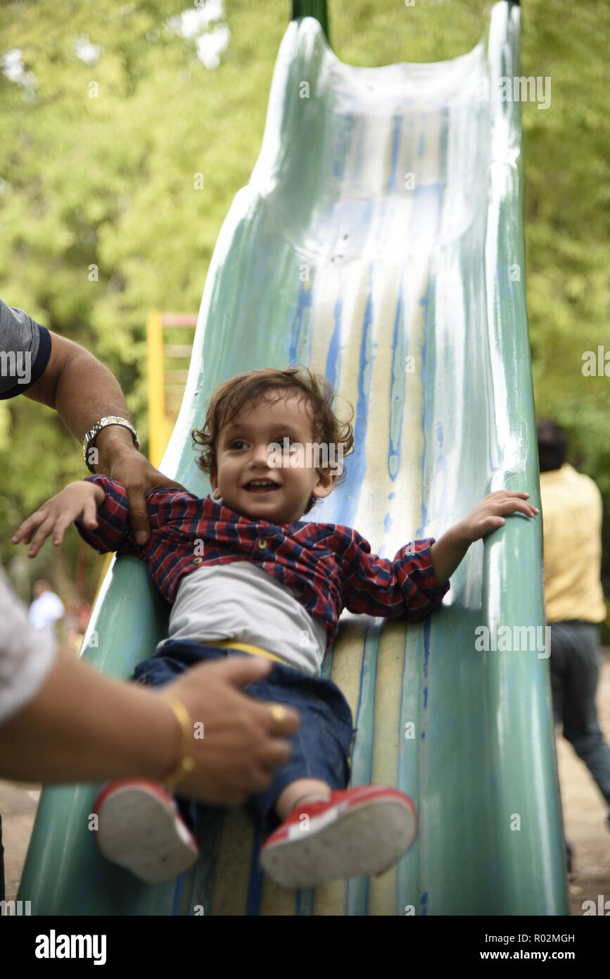 cute smiling kids enjoying play time with playful mood in amusement park or children park in New Delhi, India, Asia Stock Photo