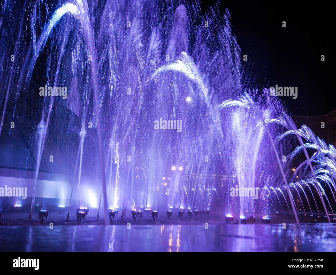 Colored water jets in the fountain at night Stock Photo - Alamy