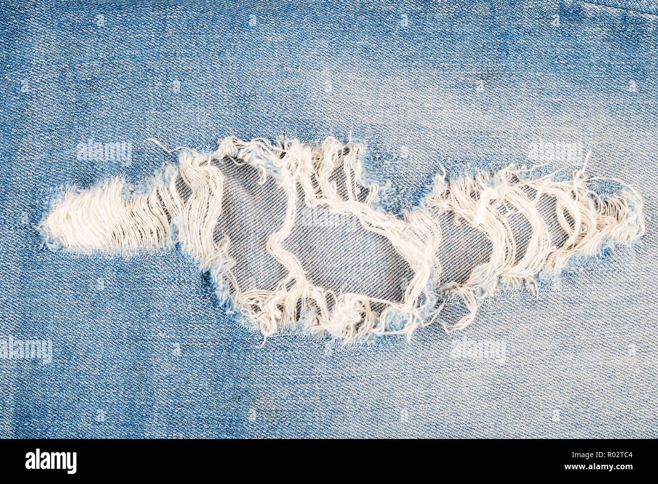 Ripped blue jeans texture background Stock Photo - Alamy