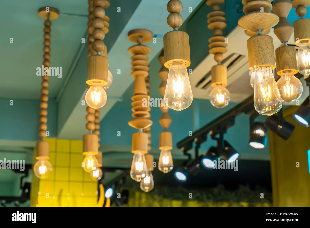 Decorative vintage edison light bulbs against striped wooden wall background. Retro lighting decor. Stock Photo