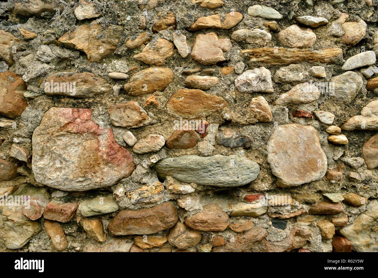 Weathered old stone wall background ocher tone Stock Photo