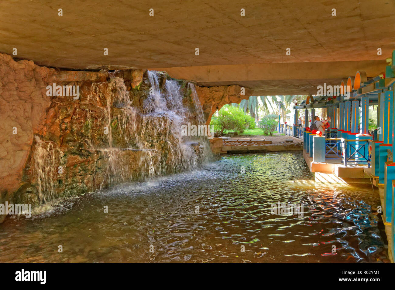 Waterfall feature under highway flyover at Bird Valley park, Vallée des Oiseaux, in central Agadir, Souss-Massa Province, Morocco, North West Africa. Stock Photo