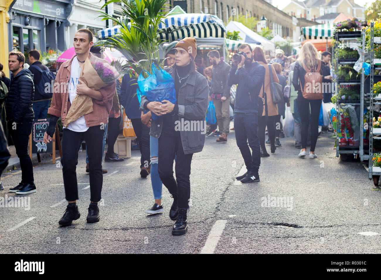 LONDON, ENGLAND - October 12, 2018 Group of young friends walking in famous Brick Lane in London. Multicultural people with mixed races wearing colour Stock Photo