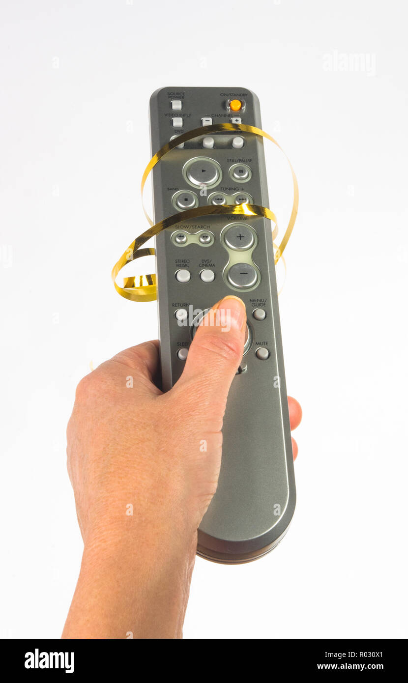 hand holding a remote control in a festive gold ribbon on white