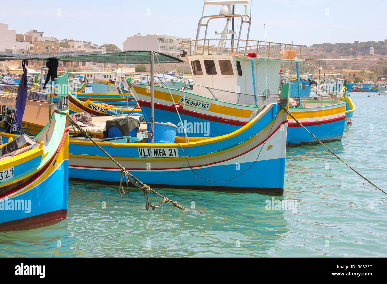 Marsaxlokk, Malta - May 2018: Beautiful view of fishing village with traditional eyed boats luzzu in sunny day Stock Photo