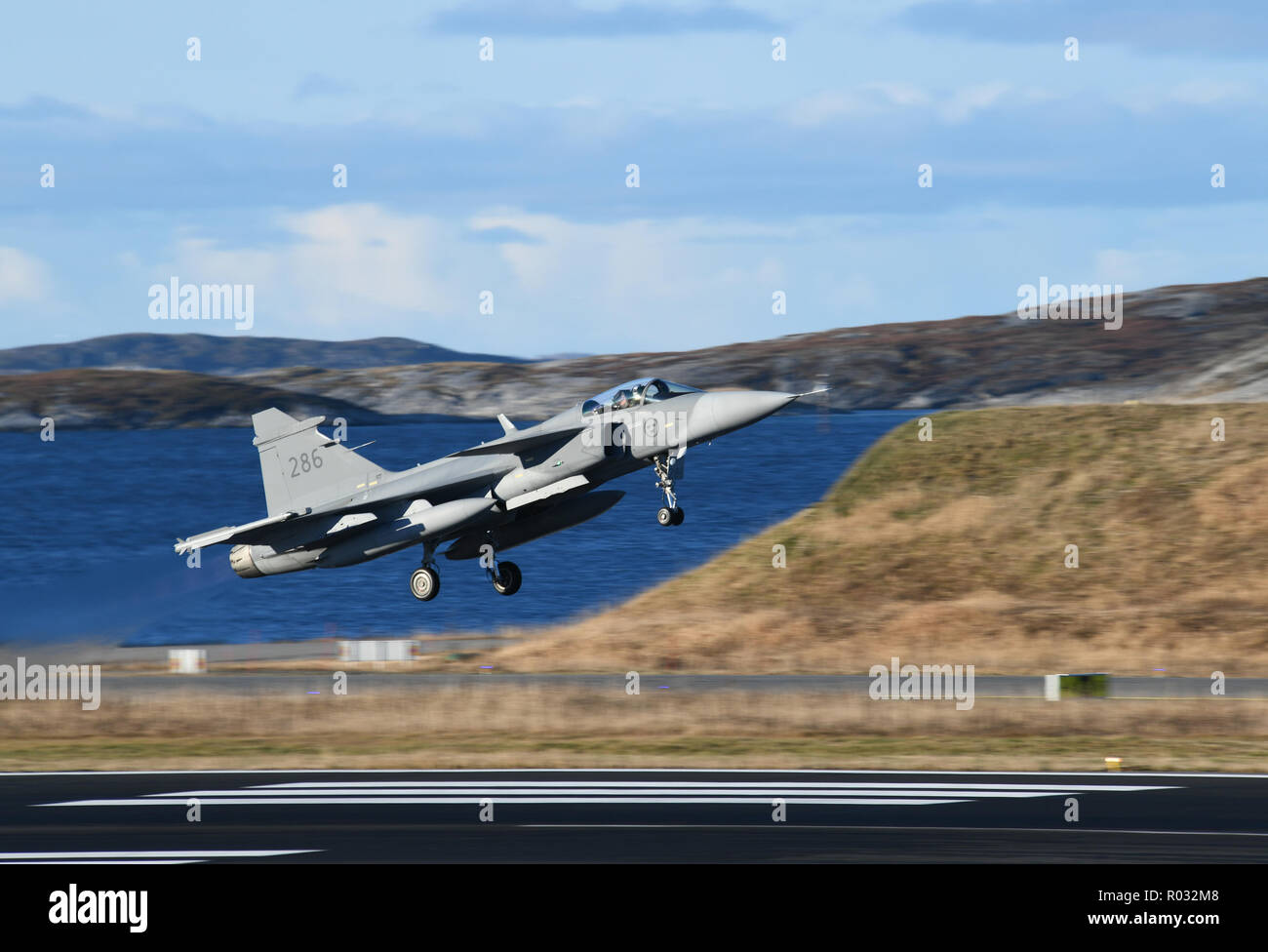 A Swedish Air Force JAS 39 Gripen lands at Bodo Air Station, Norway during exercise Trident Juncture 18 on Oct 25, 2018. Trident Juncture is a multinational NATO exercise that enhances professional relationships and improves overall coordination with Allied and partner nations. (photo by Louise Levin/Försvarsmakten) Stock Photo