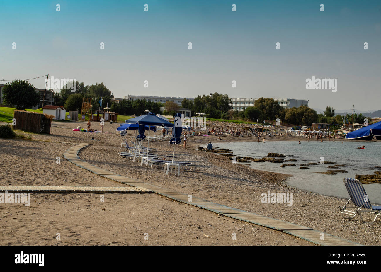 The beach at Kolymbia,Rhodes,Greece on a sunny day with people sun bathing. Stock Photo
