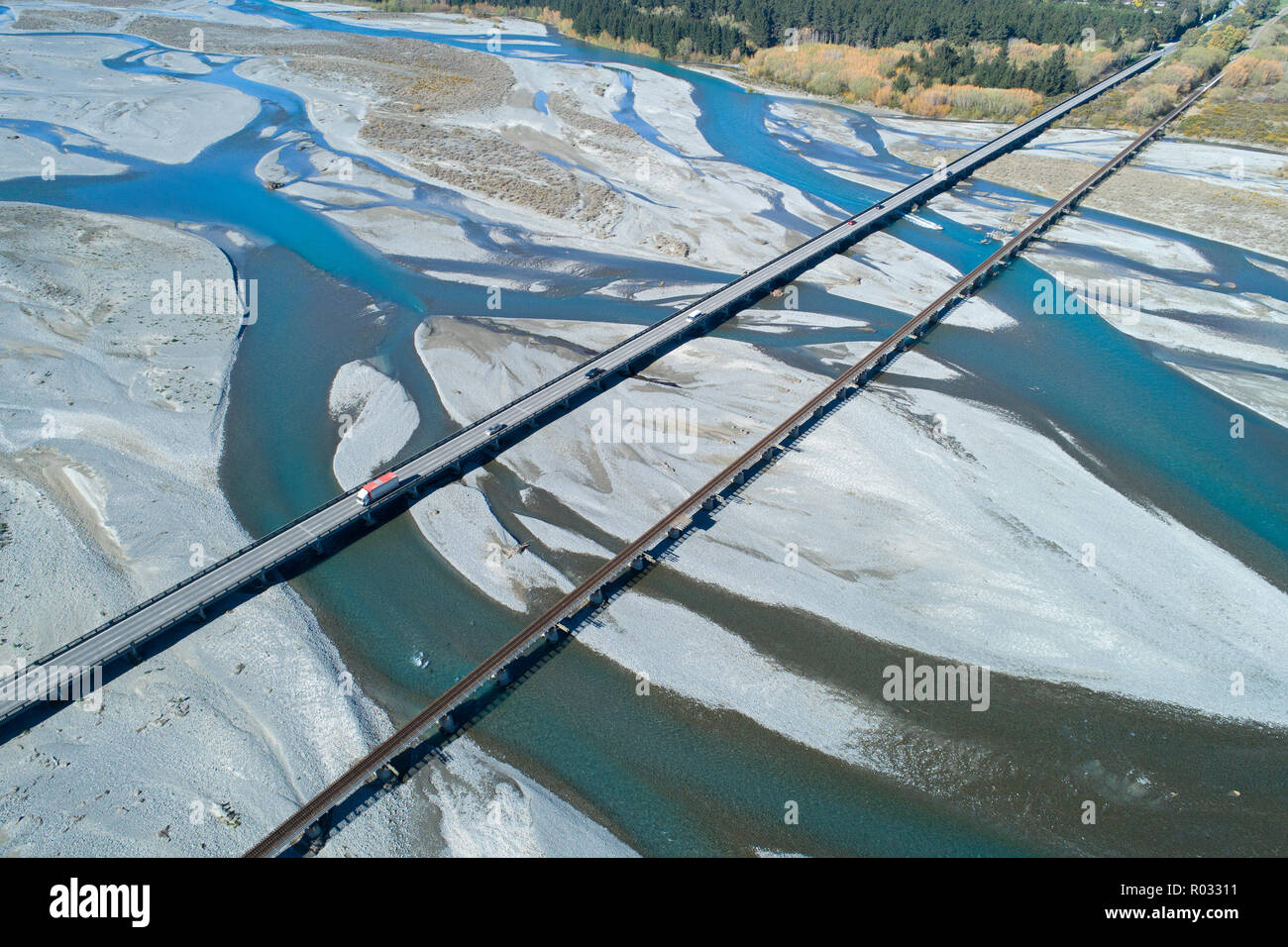 Road and rail bridges across Rakaia River, Rakaia, Mid Canterbury, South Island, New Zealand - aerial Stock Photo