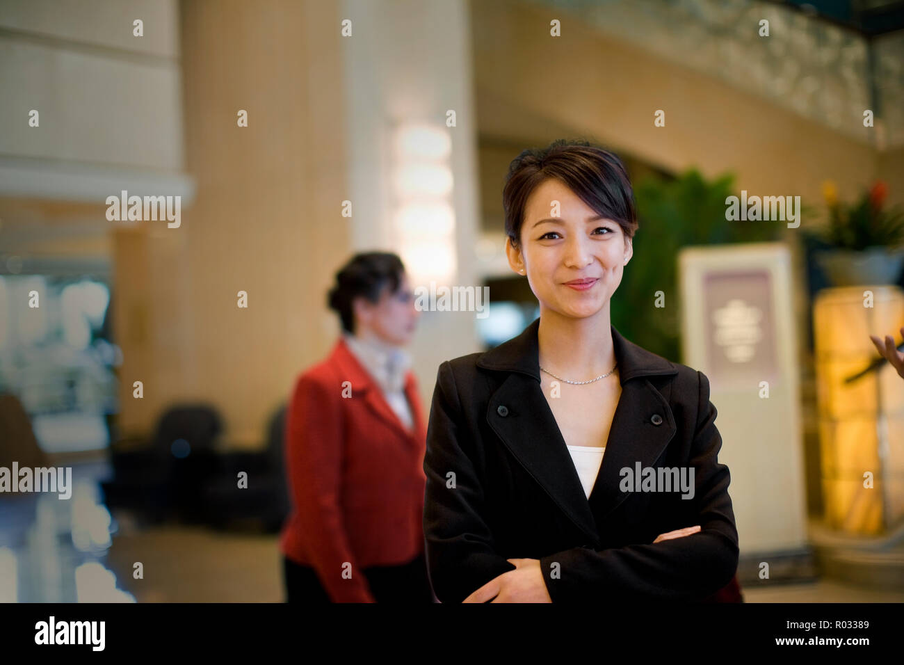 Portrait of a young adult business woman standing in a lobby. Stock Photo