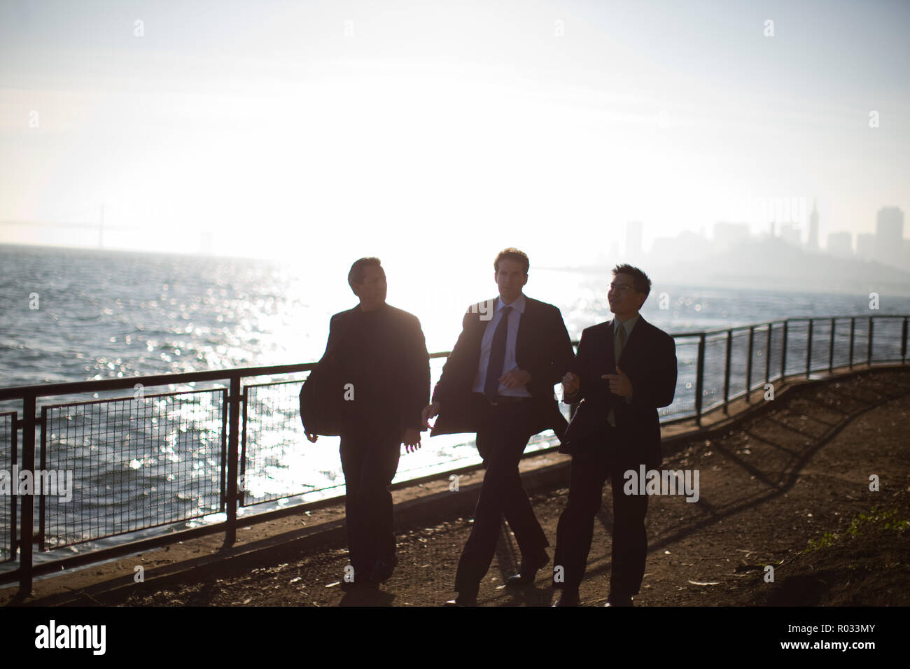 Three businessmen walking on a pier. Stock Photo