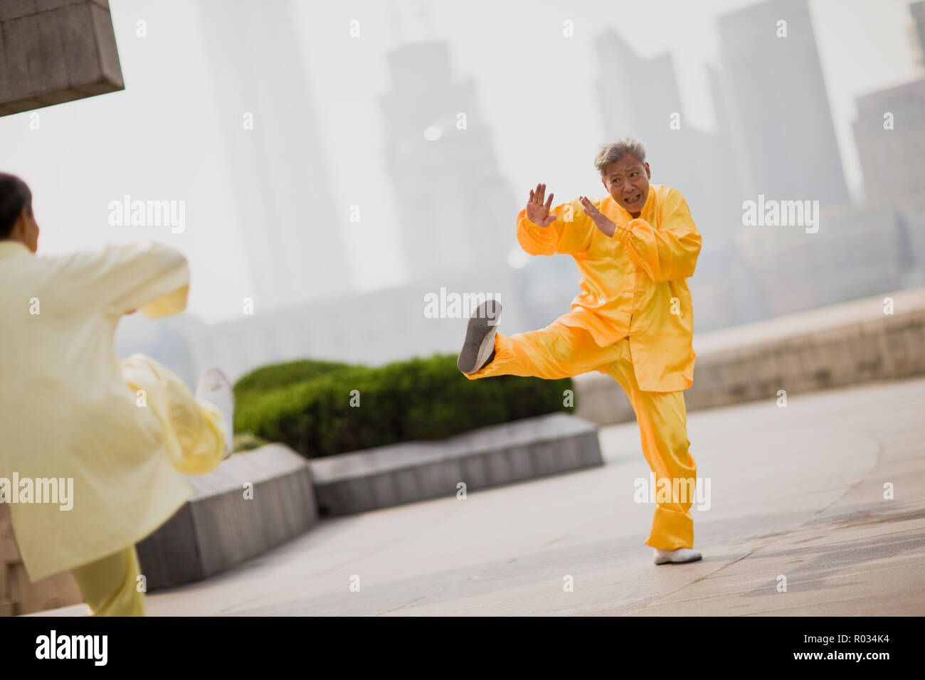 Senior man wearing traditional clothing and practicing martial arts in