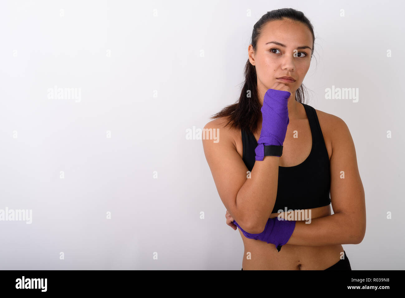Studio shot of young Asian woman fighter thinking and looking at Stock Photo