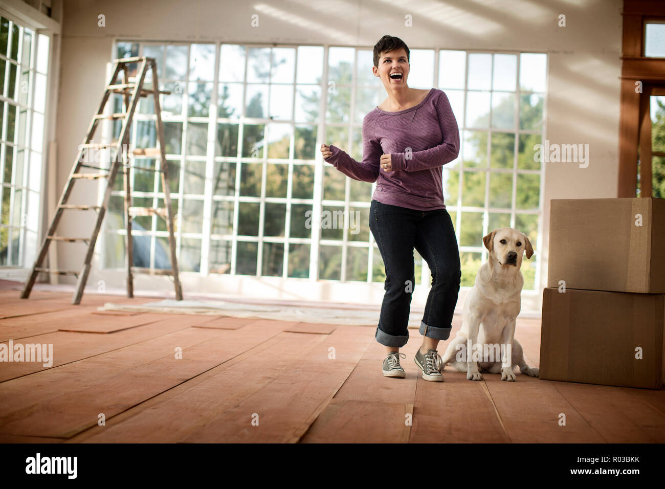 Happy young woman celebrating moving into a new house. Stock Photo