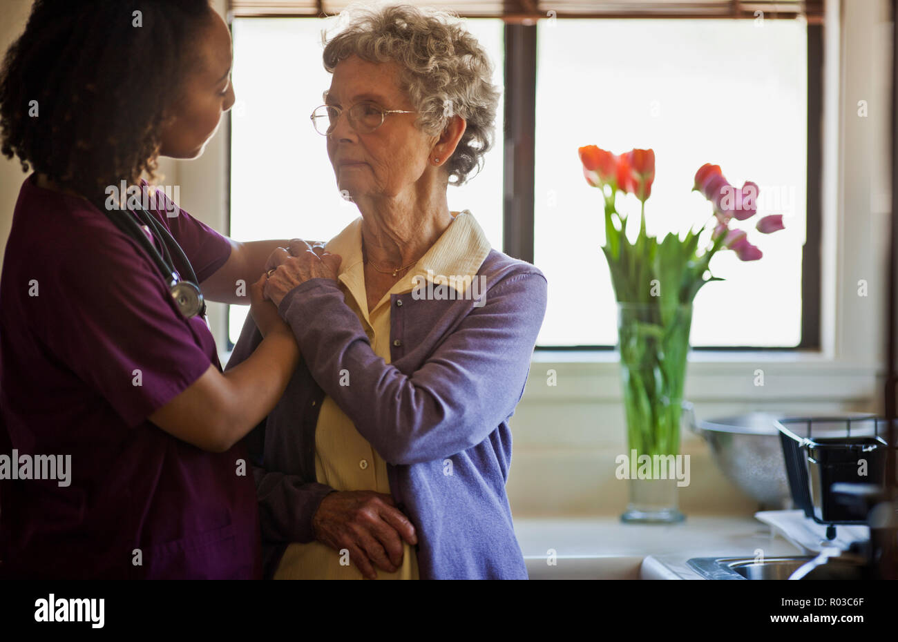 Young nurse comforting a grieving senior woman Stock Photo Alamy