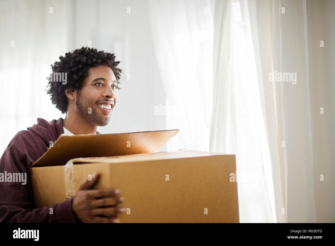 Happy young man moving into a new home. Stock Photo