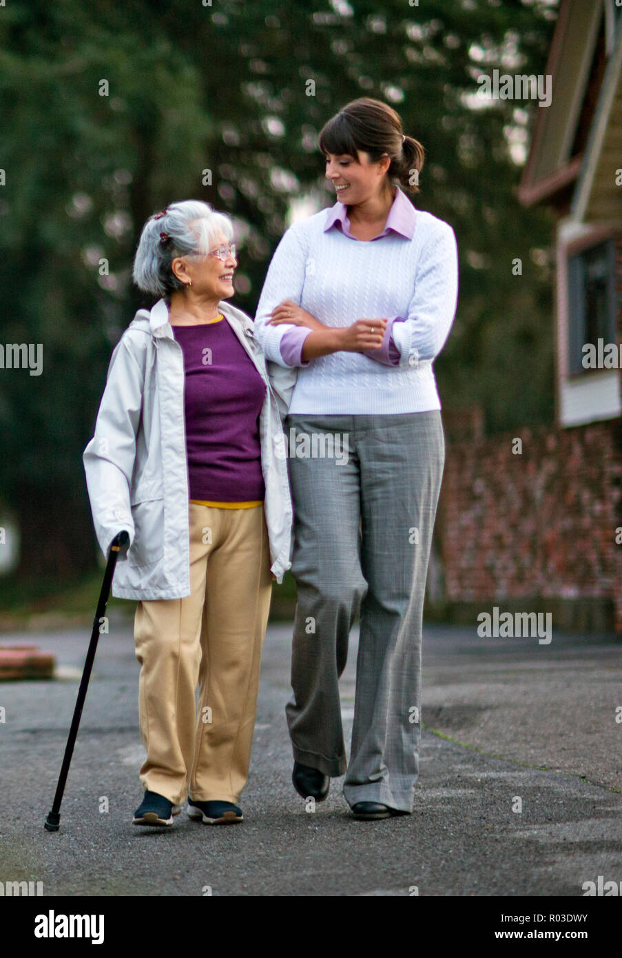 Elderly Woman Walking Arm In Arm With Her Doctor Stock Photo Alamy