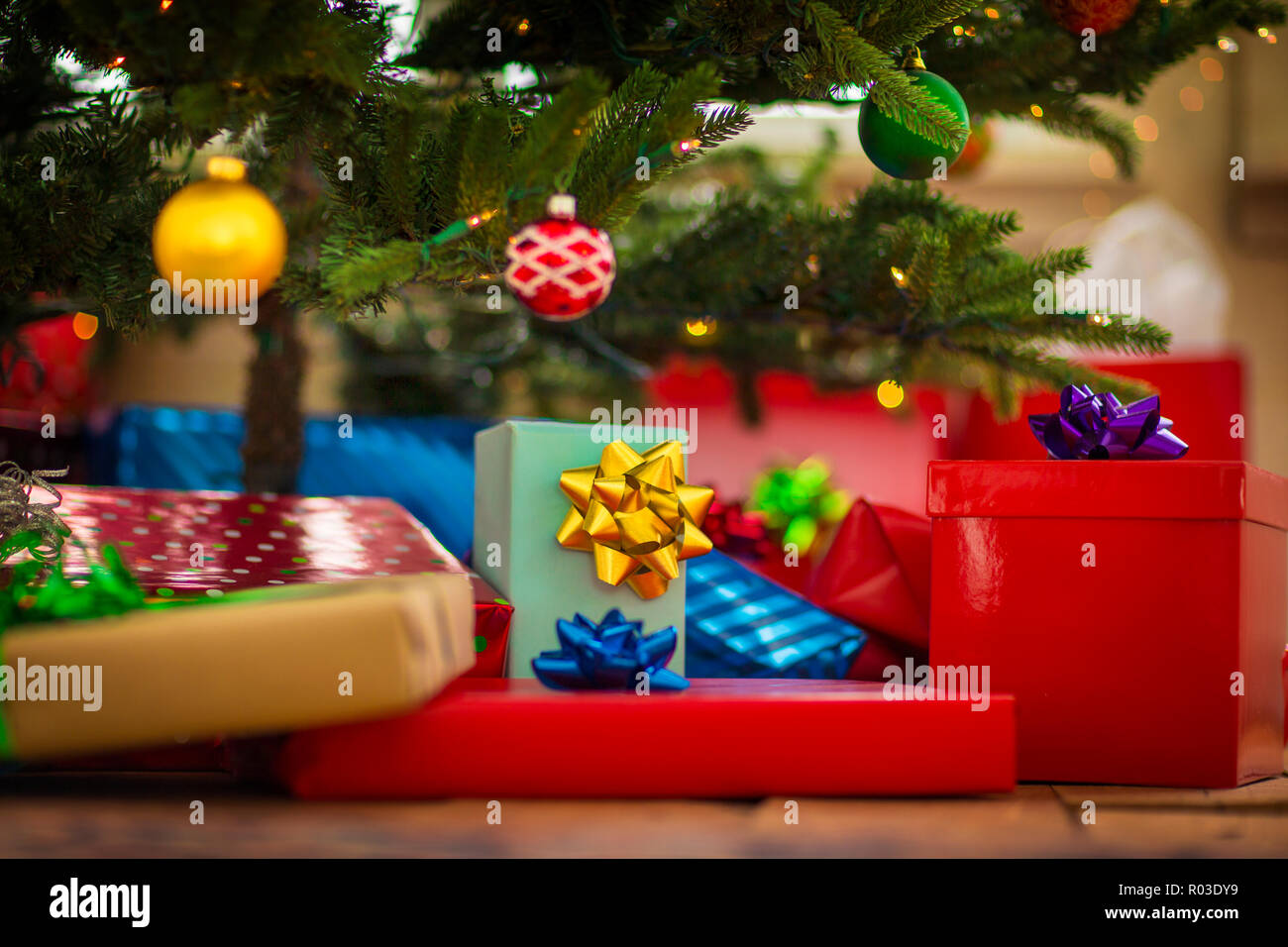 Wrapped Christmas presents waiting under a Christmas tree. Stock Photo