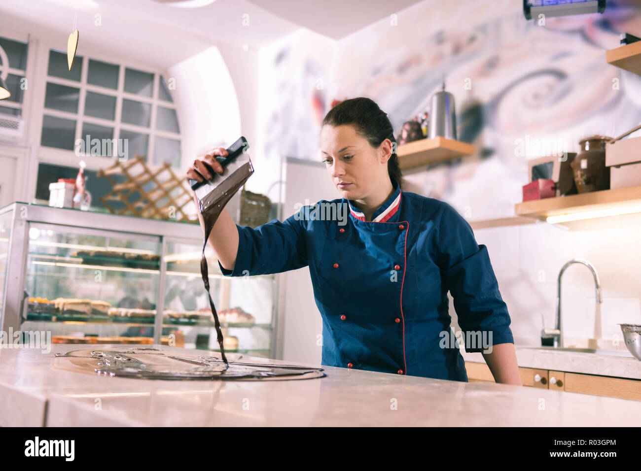 Experienced female chocolatier cooking amazing tempered chocolate Stock Photo