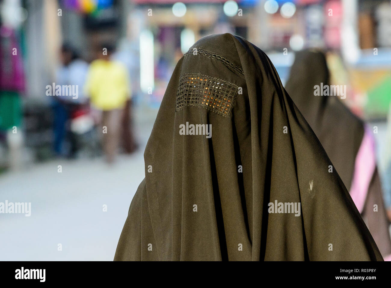 The Burga, covering the whole body and the face, is an black outer garment worn by many Kashmiri women and female teenagers in public spaces Stock Photo