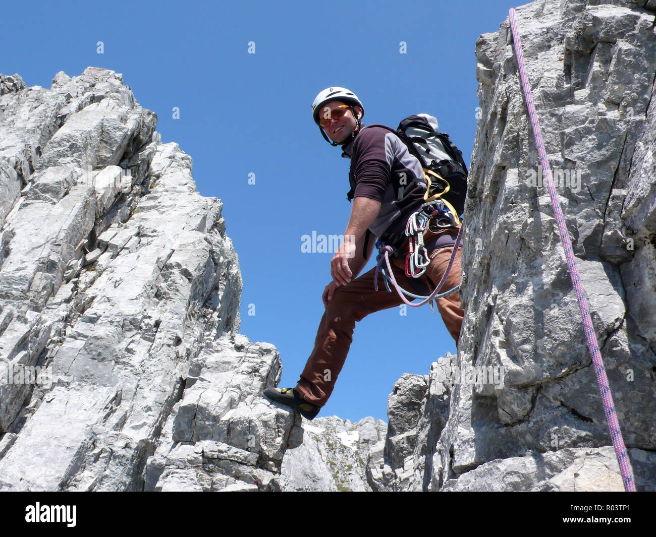 mountain guide rock climbing in the Alps of Switzerland in the Raetikon region near Klosters on a beautiful summer day Stock Photo