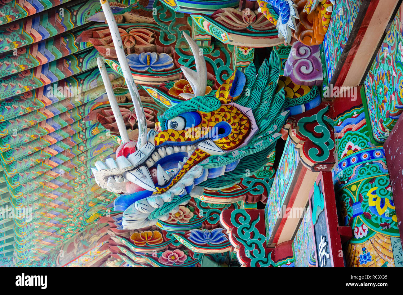 An ornately carved and painted wooden detail at Haedong Yonggungsa Temple, a Buddhist temple in Busan, South Korea Stock Photo