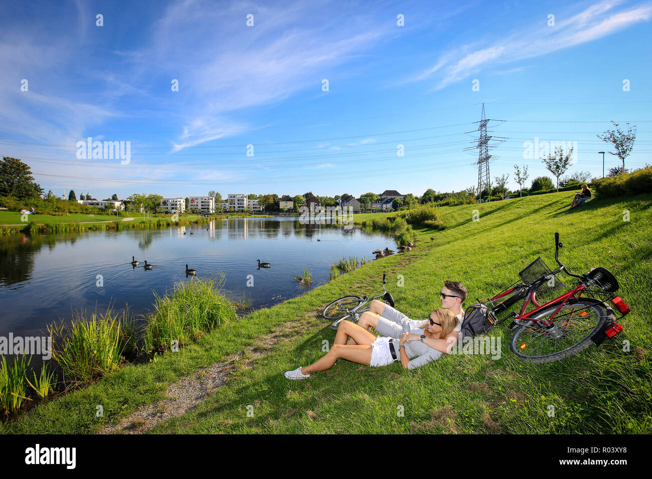 Essen, Ruhr area, Germany, urban development project Niederfeldsee, young couple lies in the meadow Stock Photo