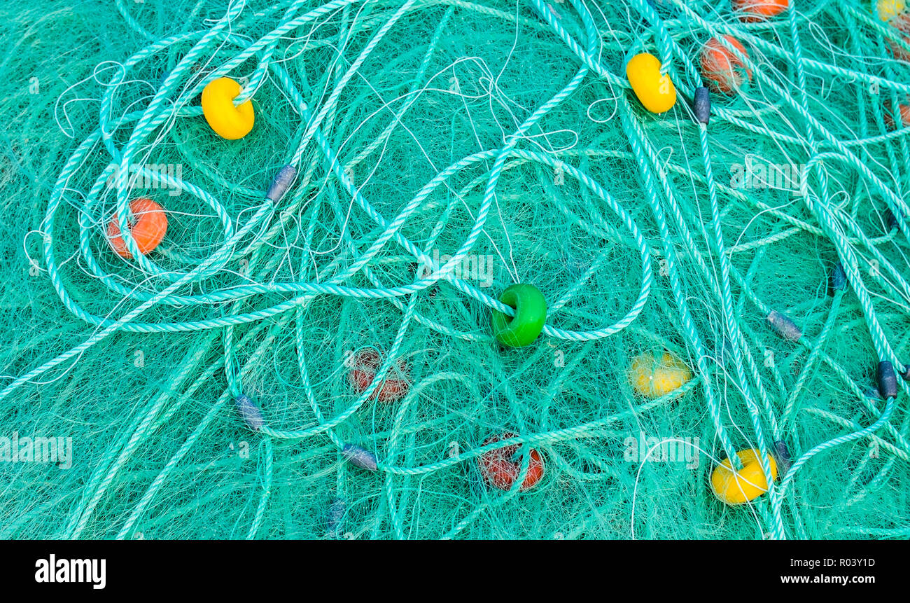 turquoise-colored fishing net with colorful floats Stock Photo
