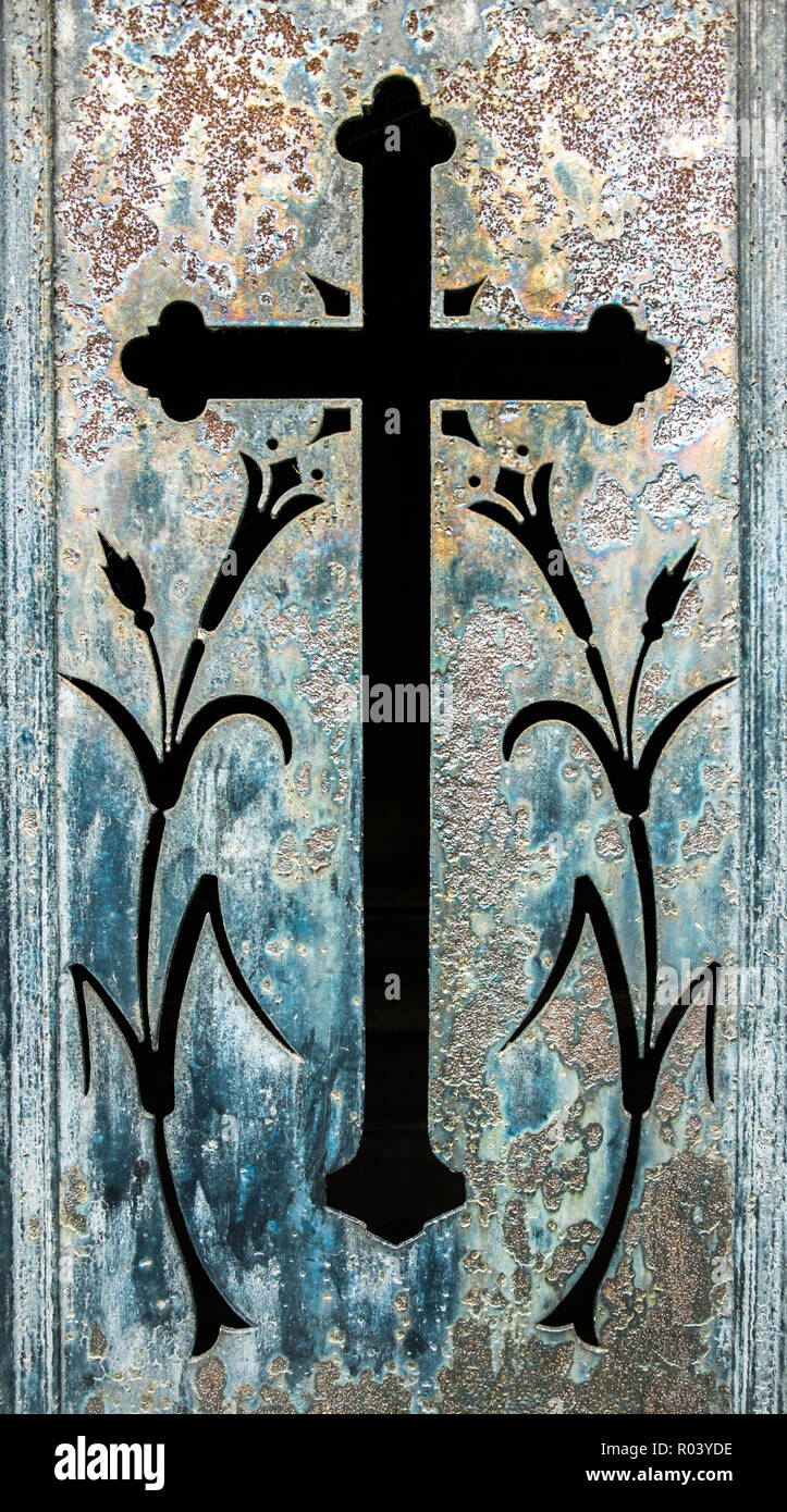 historic metal door showing a cross and floral ornaments Stock Photo