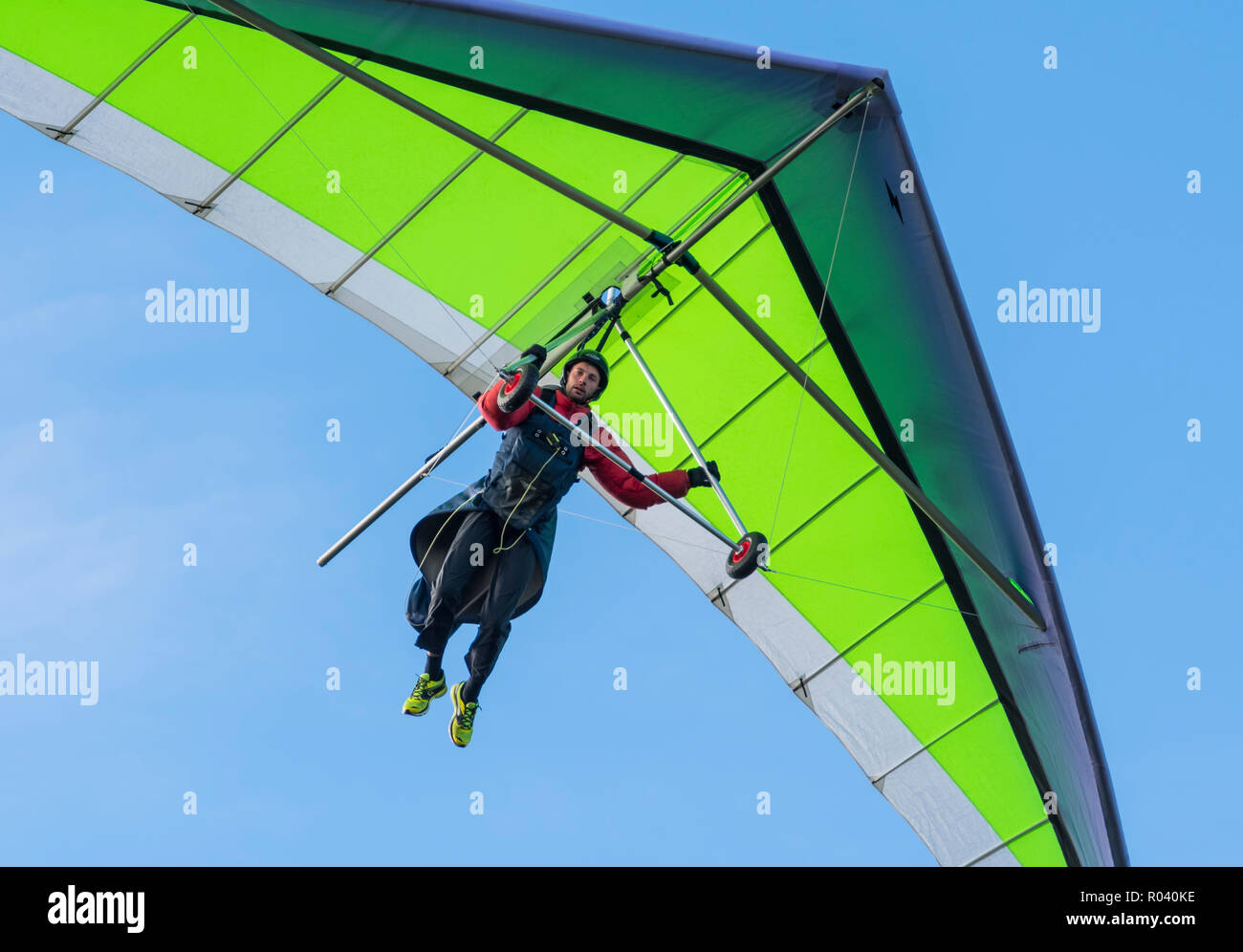 Man hang gliding in Autumn with blue sky, looking for a place to land on the South Downs in East Sussex, England, UK. Stock Photo