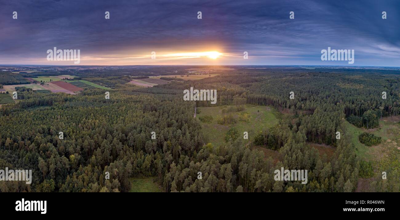 Beautiful sunset  with strange clouds over forest. Drone landscape. Stock Photo