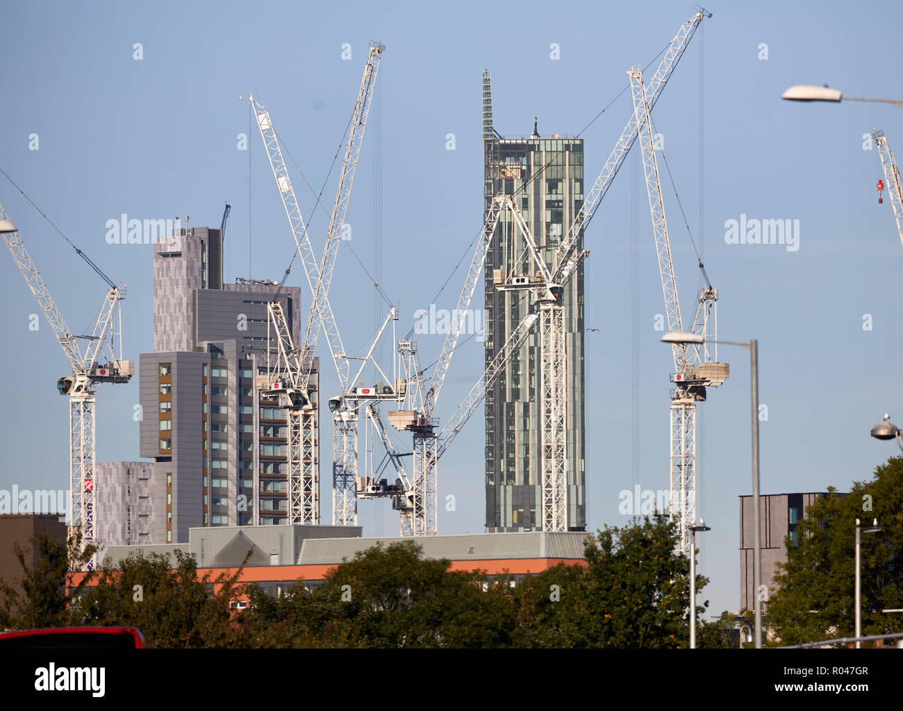 Betham tower frames the many tower cranes in the university area of Manchester city centre Stock Photo