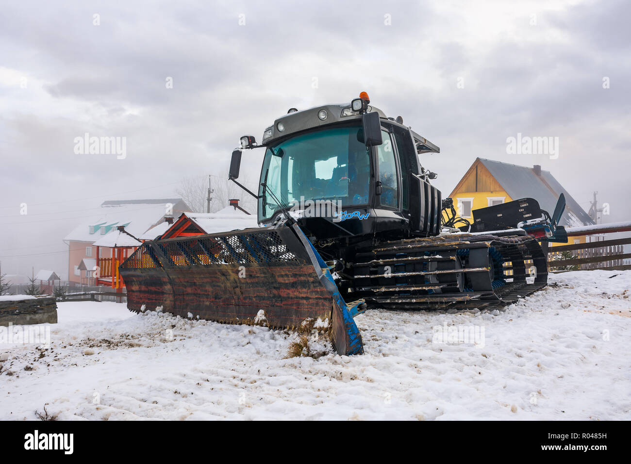 Pylypets, Ukraine - DEC 21, 2016: snow groomer parked in the resort village. huge machinery without a work on a cloudy winter day Stock Photo