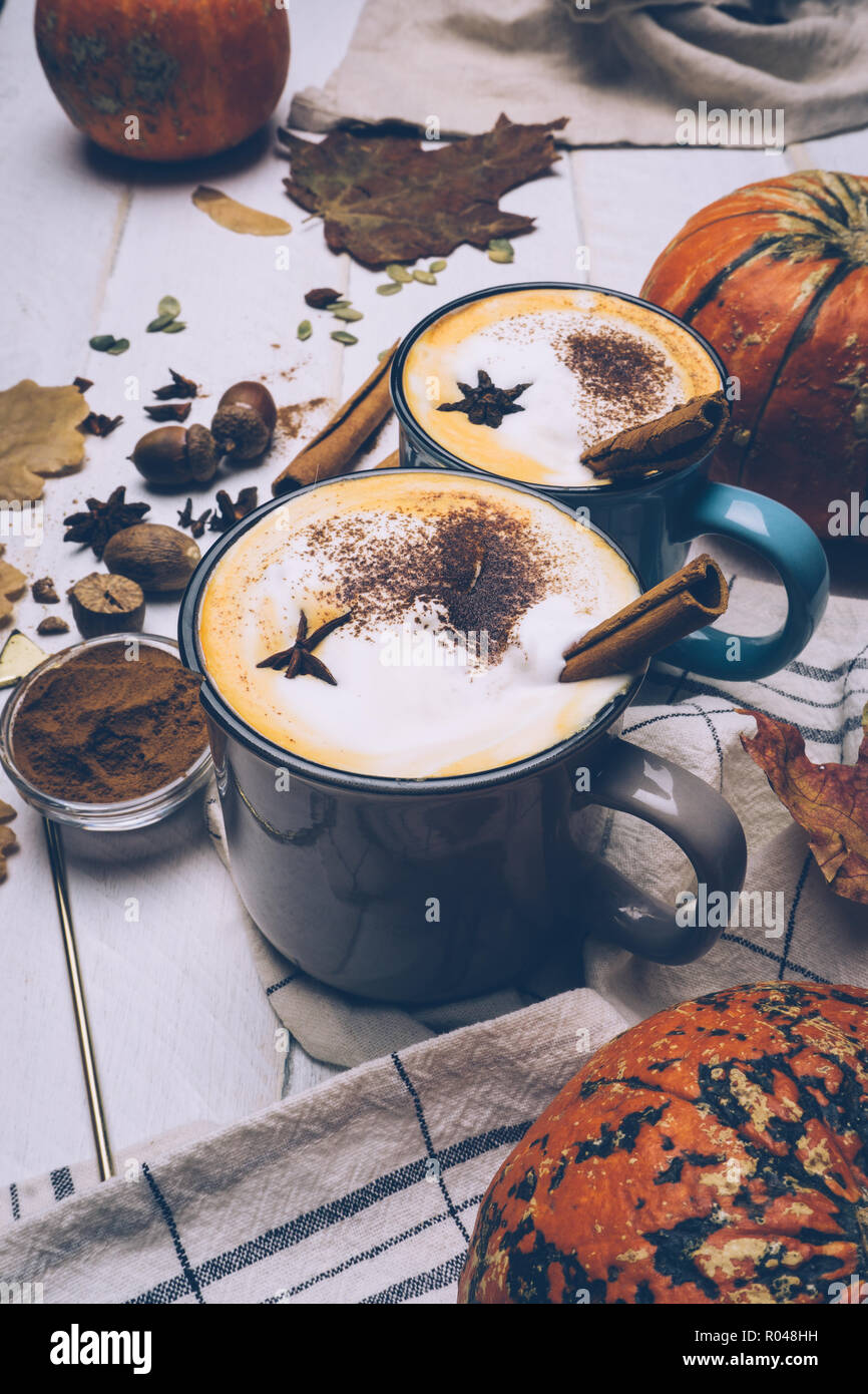 https://c8.alamy.com/comp/R048HH/pumpkin-spice-latte-or-coffee-with-cinnamon-and-nutmeg-autumn-fall-or-winter-hot-drink-old-white-wooden-background-with-yellow-leaves-and-pumpkins-R048HH.jpg