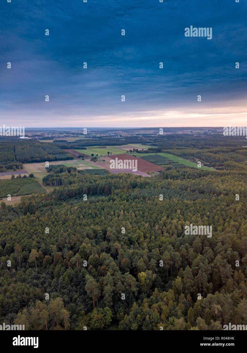 Beautiful sunset  with strange clouds over forest. Drone landscape. Stock Photo
