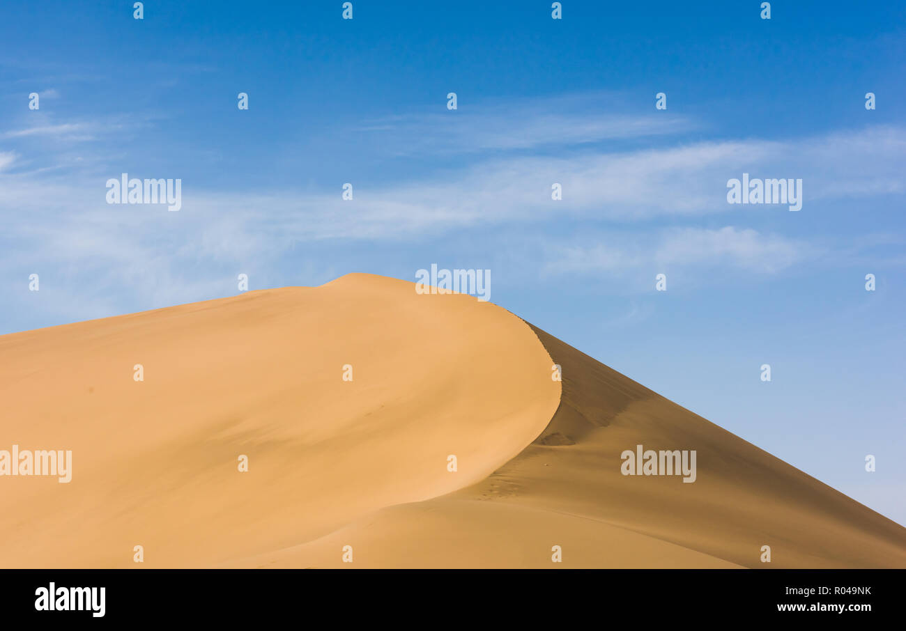 Desert sand dunes with blue sky background. Beautiful curves of deserts Stock Photo