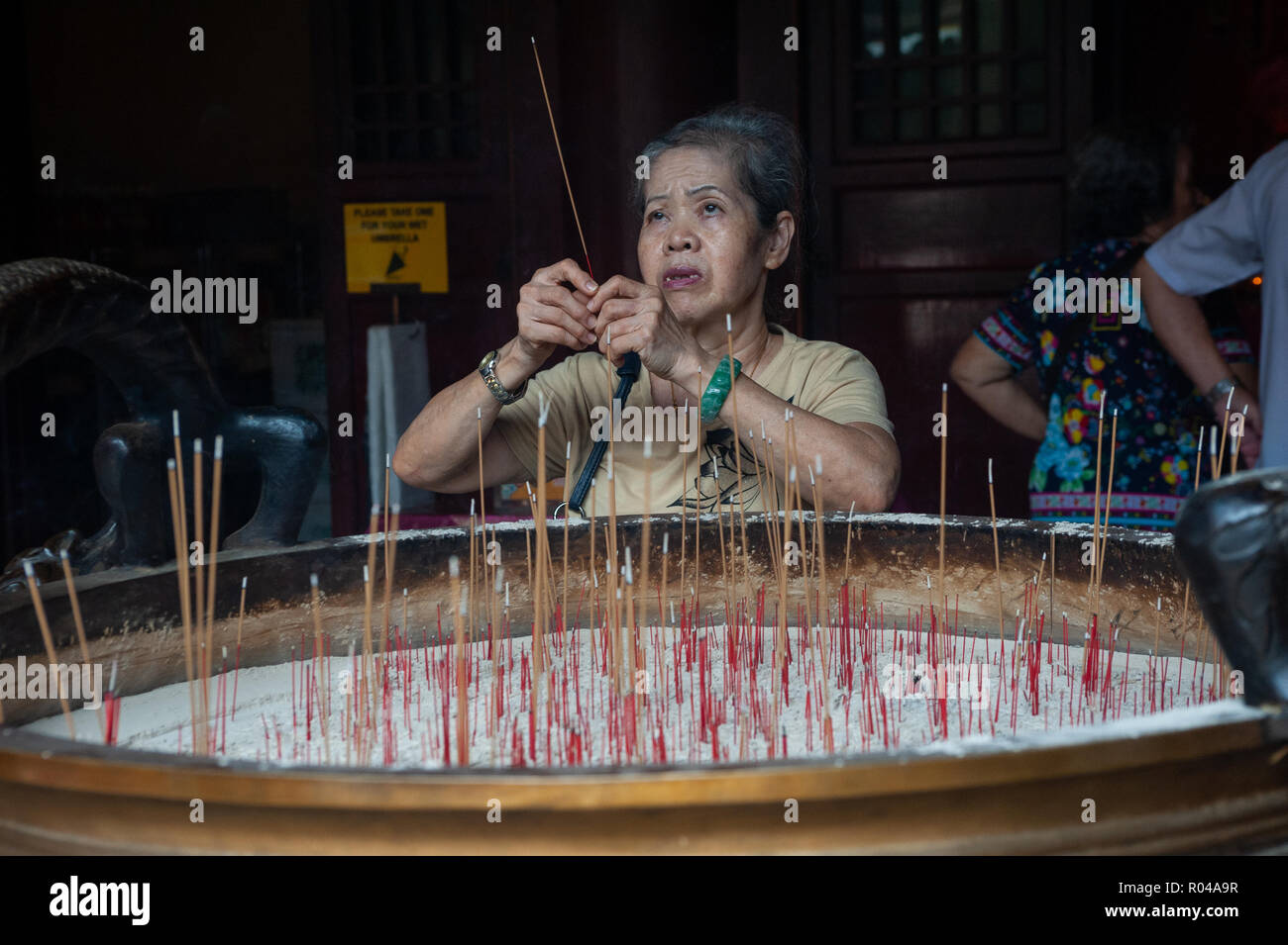 Republic of Singapore, woman praying in Buddha Tooth Relic Temple Stock Photo