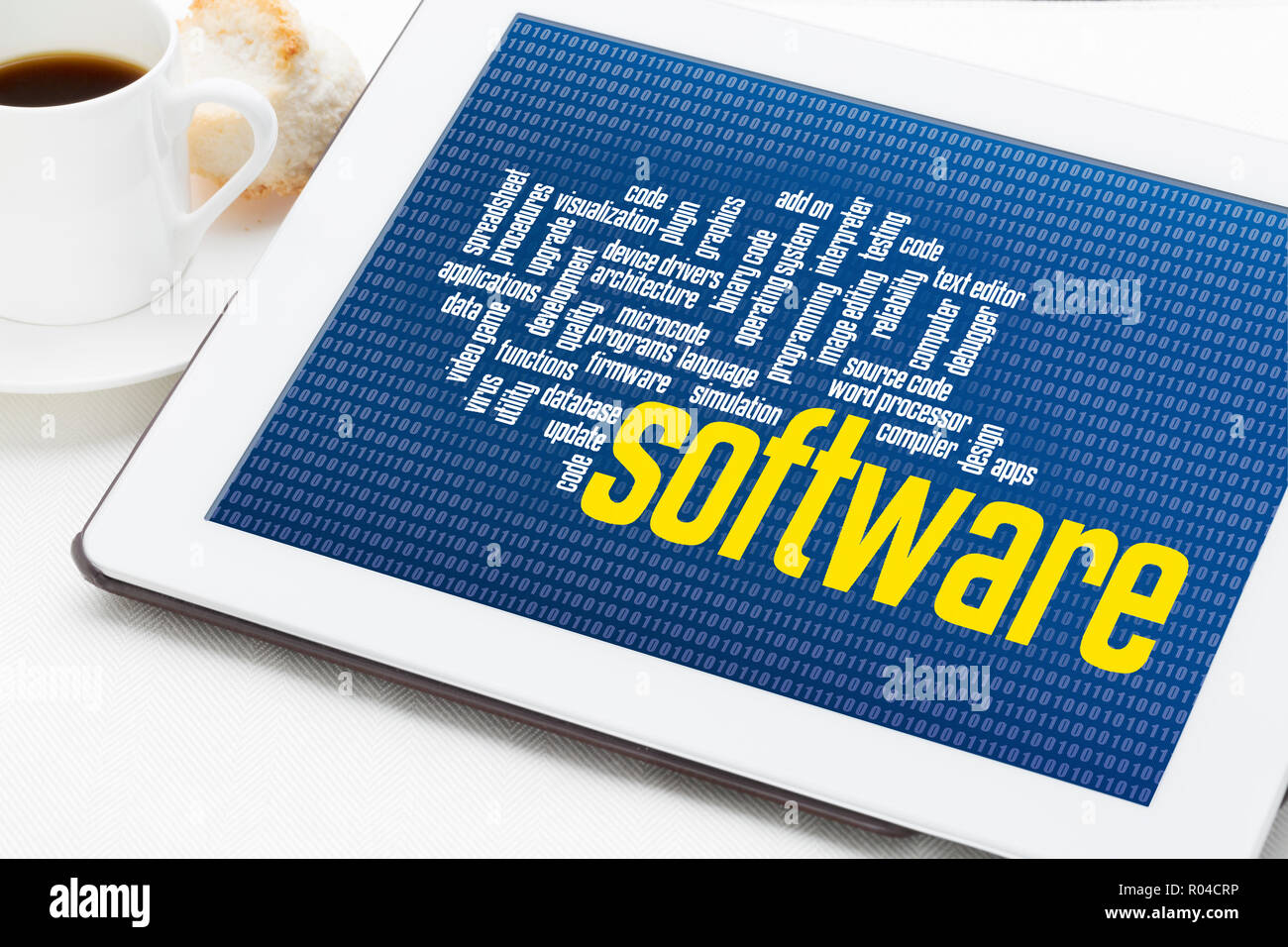 computer software word cloud on zero one binary background - digital tablet with a cup of coffee Stock Photo
